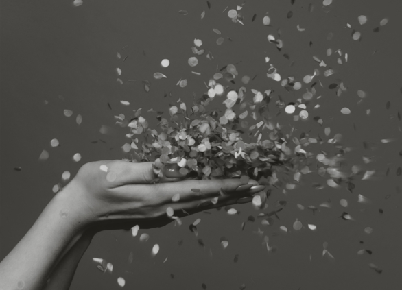 Two hands of a woman throwing confetti